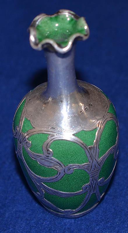 MINIATURE CERAMIC VASE WITH ORNATE SILVER HALL MARKED OVERLAY.